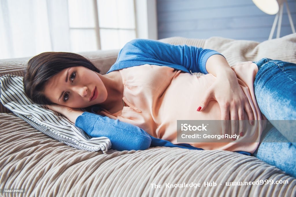 Beautiful pregnant woman Beautiful pregnant woman is keeping one hand on a belly and looking at camera while lying on couch at home 18-19 Years Stock Photo
